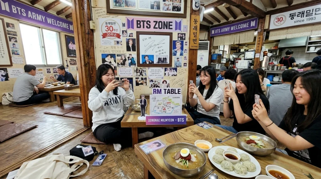 Traditional Korean floor seating, BTS Zone with RM autograph on wall, ARMY fans taking photos, cold Mul-milmyeon and dumplings 