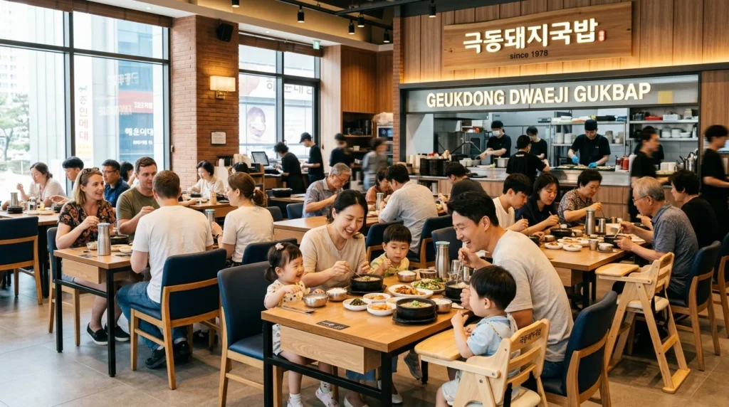 Busy dining scene during peak hours with diverse customers including families with children at four-seater tables, baby chairs visible, demonstrating family-friendly upscale atmosphere near Haeundae tourist area