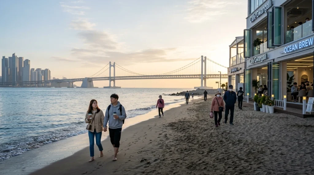 Peaceful morning at Gwangalli Beach, travelers with coffee on sandy beach, Gwangan Bridge across calm ocean, beachfront cafes 