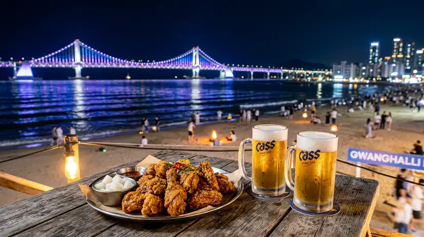 Golden Korean fried chicken and frosty beer mugs on wooden table with illuminated Gwangandaegyo Bridge at night