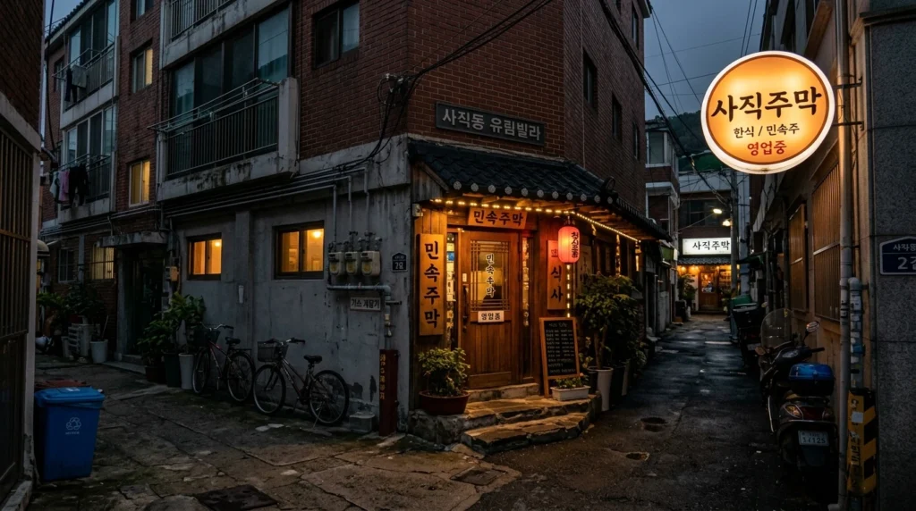 Traditional illuminated restaurant sign in quiet residential alleyway near Sajik Station